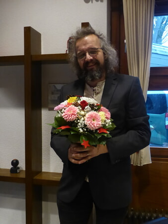 Thomas Detscher überreicht einen Blumenstrauß zur Ehrung